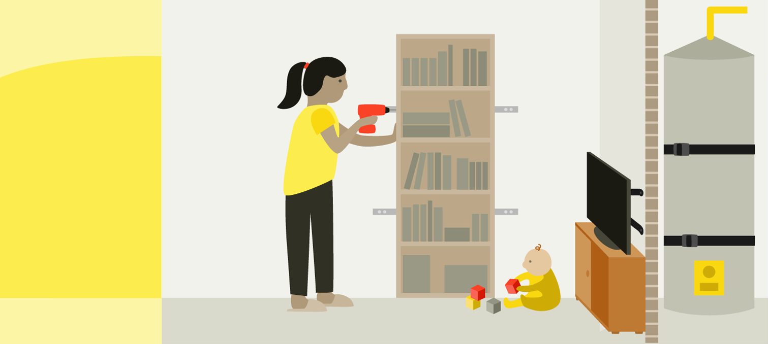A woman attaching a bookcase to the wall with metal brackets and a drill.  A child is playing under the bookcase. The child is also close to a TV on top of a cabinet. 